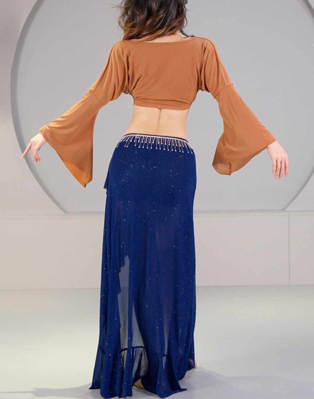 背面から見たベリーダンスのレッスン着スタイル。トップスの袖の広がりとスカートの落ち感が分かり、衣装としての後ろ姿を確認できる写真。