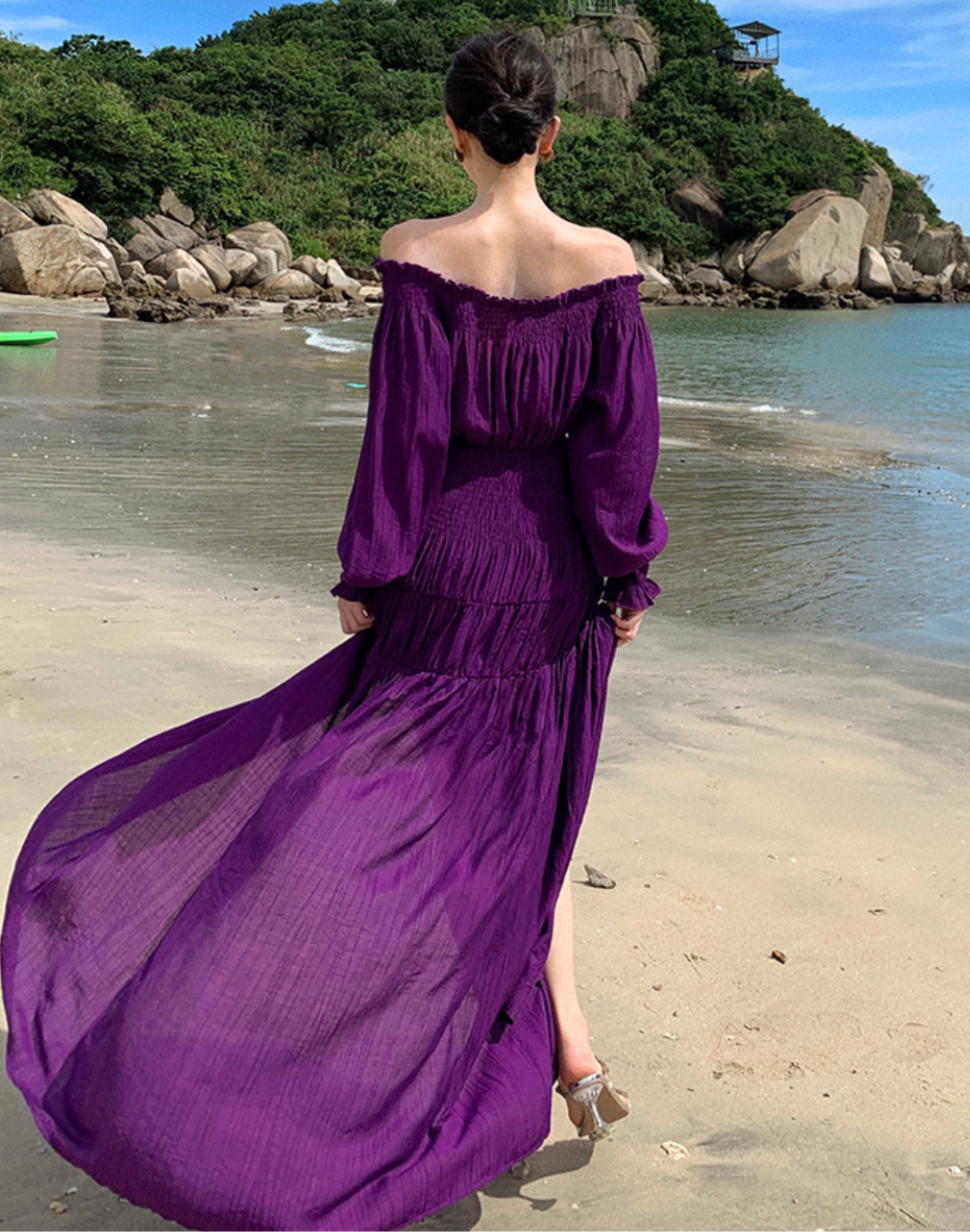 海辺でワンピースの裾が大きく風に揺れる後ろ姿の写真。軽く柔らかな素材がベリーダンスのレッスン着や衣装にも重ねやすく、動きのあるシルエットが分かるショット。