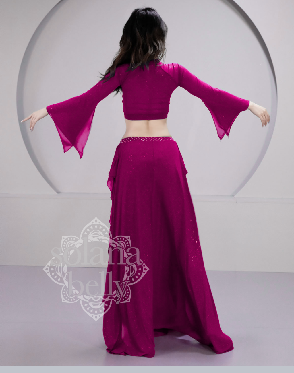 背面から見たピンクのベリーダンス レッスン着 衣装、柔らかな素材が動きに合わせて自然に揺れるシルエット