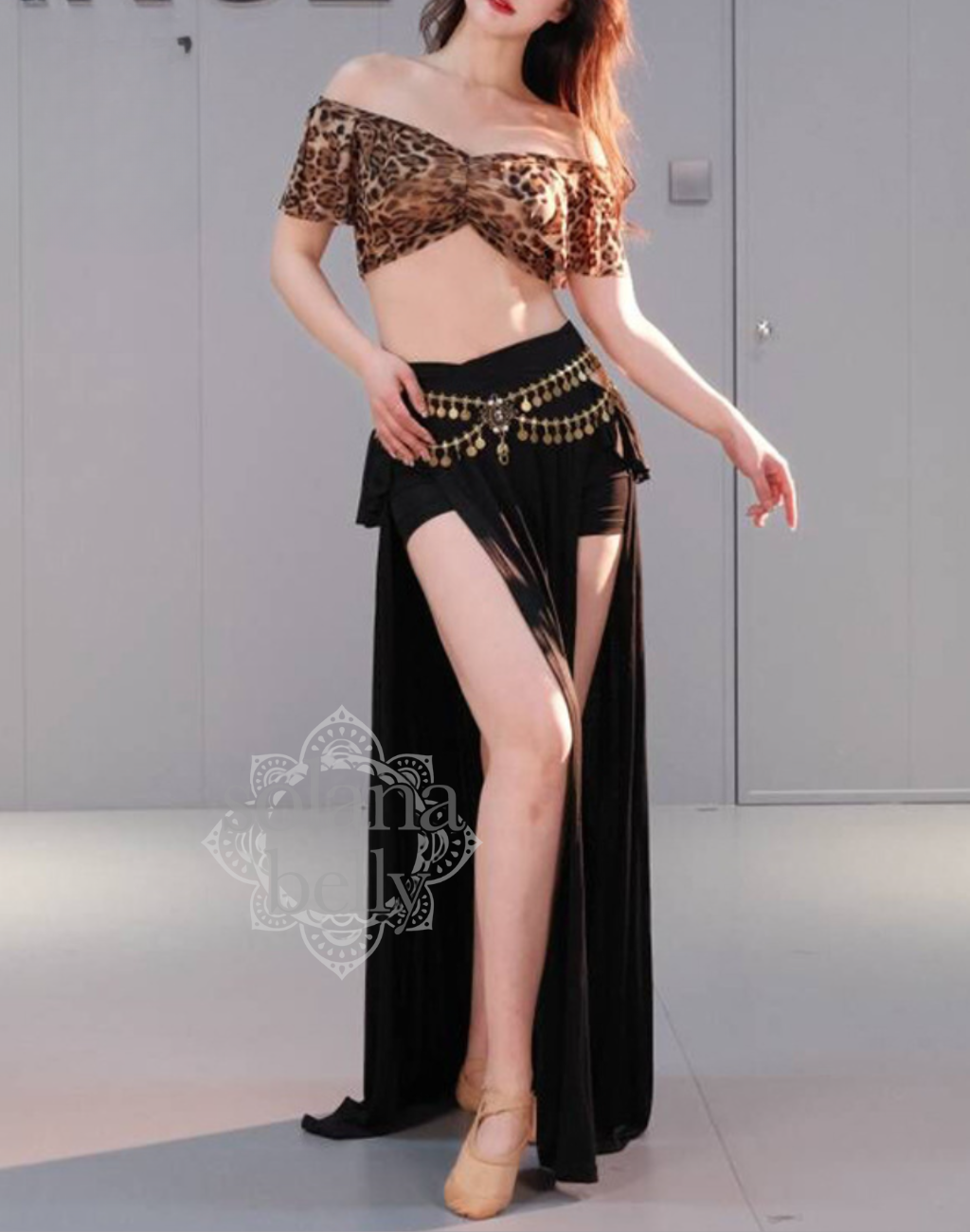 ベリーダンス レッスン着 衣装にもなるデザイン。レオパード柄ののセットアップを着用した女性。肩まわりを美しく見せる白トップスと、脚長効果のあるブルースカートの組み合わせ。初心者向けの安心デザイン。