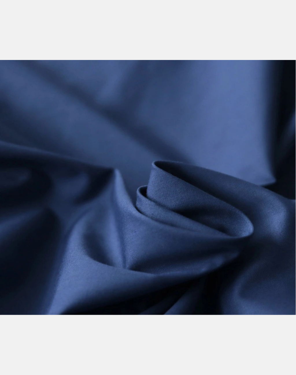 袖のボリュームとハリのある素材感がわかるネイビーのガラベーヤワンピースのディテール写真。レッスン着の上から羽織っても動きやすい構図。