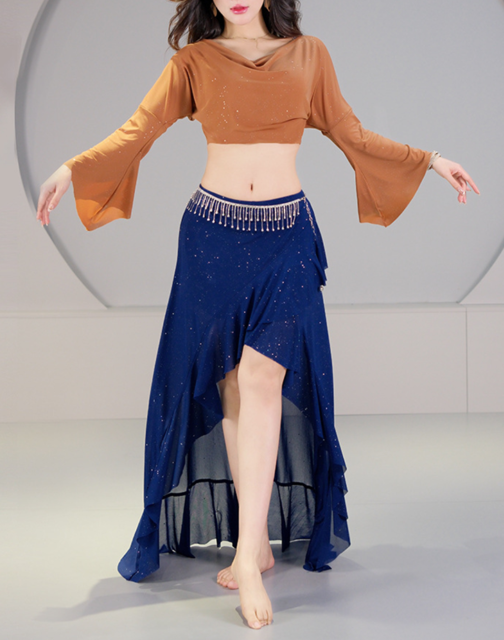 腕を広げたポーズで着用した、ベリーダンスのレッスン着。フィッシュテールのスカートが動きに沿って揺れ、衣装としても映える全身バランスが分かる構図。