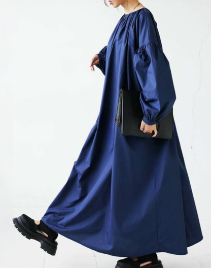 ネイビーのガラベーヤワンピースを歩いた瞬間を捉えた写真。発表会や移動中にも扱いやすいシルエットが見える構図。