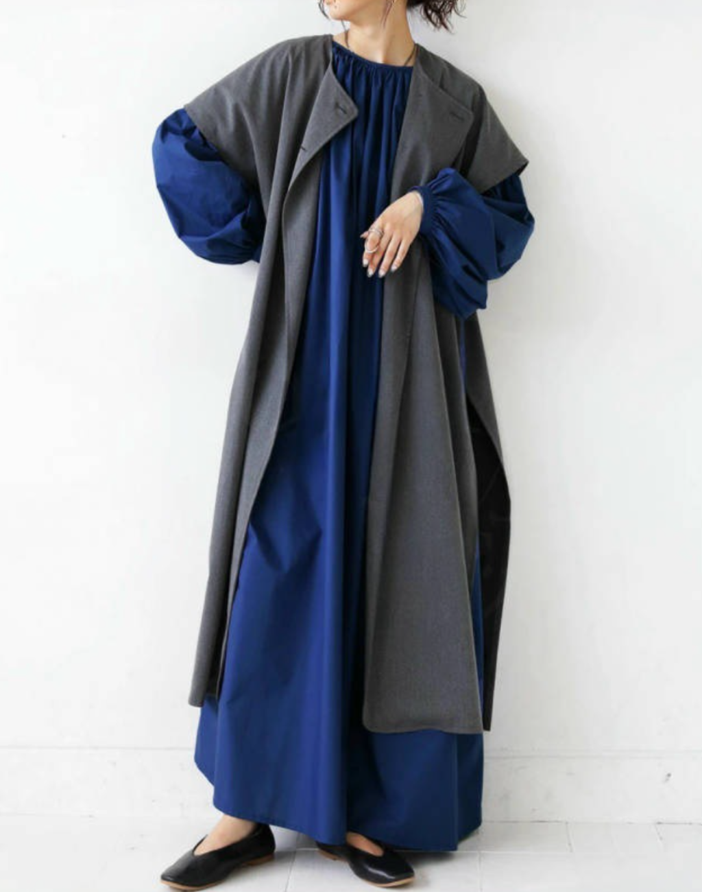 ネイビーのガラベーヤワンピースにロングジレを重ねたコーデ例。ベリーダンス衣装の上だけでなく普段使いにもなじむ着こなし。