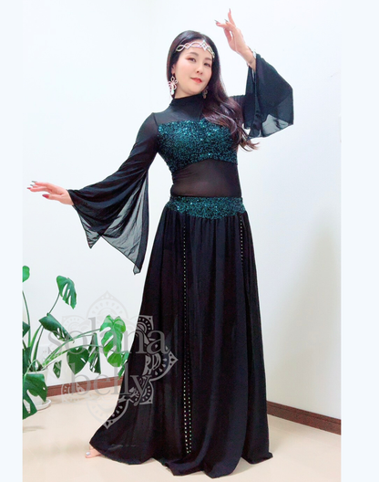 黒のトップスとスカートが一体となったデザインを着用するベリーダンス レッスン着 衣装、袖口が広がりガラベーヤワンピース風に見えるスタイル