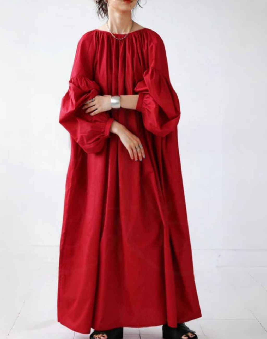 ベリーダンスの衣装やレッスン着の上から羽織れるガラベーヤワンピースを、レッドのカラーで全身が見える角度から着用している写真。