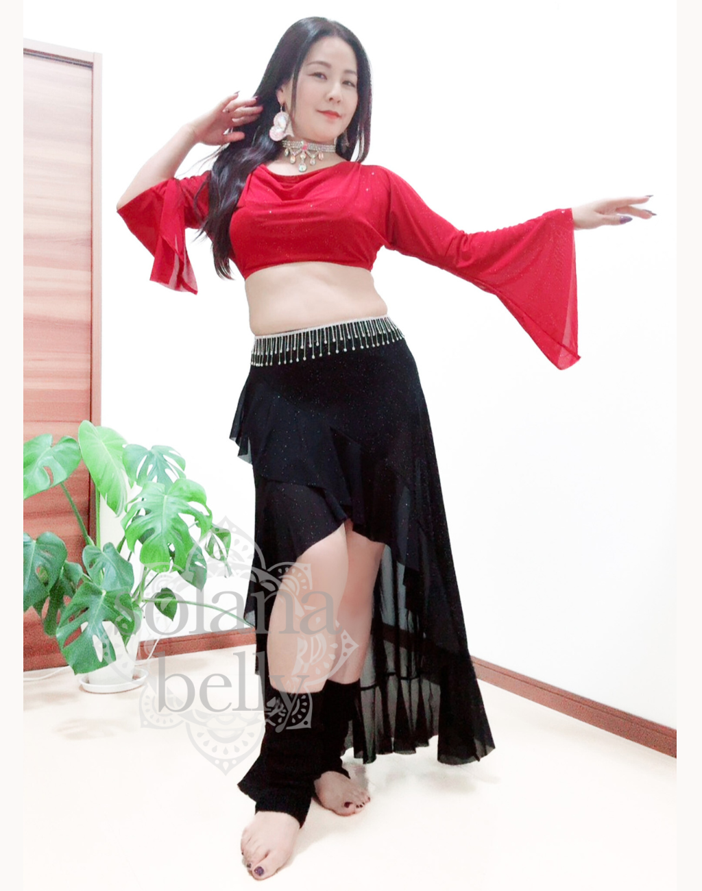 ベリーダンス衣装としても使えるレッスン着を着用しポーズをとっているベリーダンサーの画像。初心者も挑戦しやすい長袖タイプのデザイン。