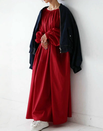 レッドのガラベーヤワンピースを日常の羽織りと合わせ、ベリーダンス衣装の上だけでなく普段使いもしやすい印象が伝わる構図。