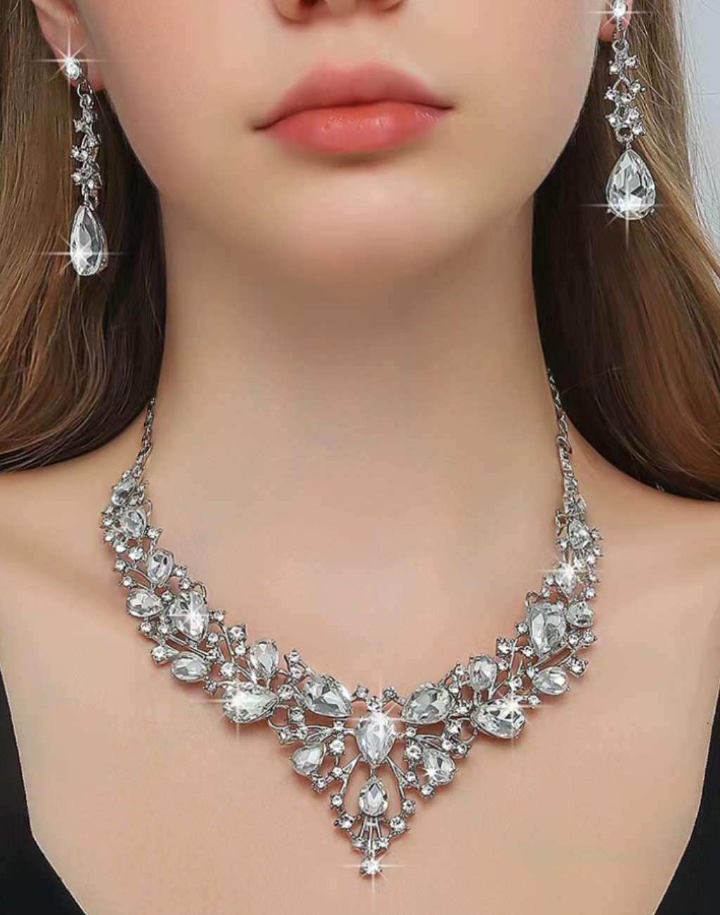 モデルがビジューのネックレスとイヤリングを着用したアップ写真。ベリーダンスのステージ衣装に合わせるアクセサリーとして、胸元の輝きと耳元の揺れが落ち着いた存在感を添える表情を捉えている。