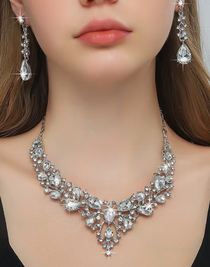 モデルがビジューのネックレスとイヤリングを着用したアップ写真。ベリーダンスのステージ衣装に合わせるアクセサリーとして、胸元の輝きと耳元の揺れが落ち着いた存在感を添える表情を捉えている。