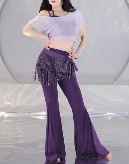 淡いラベンダーのトップスと深いパープルのワイドパンツ、ヒップスカーフを着用した女性モデル。ベリーダンス衣装にも使えるレッスン着。