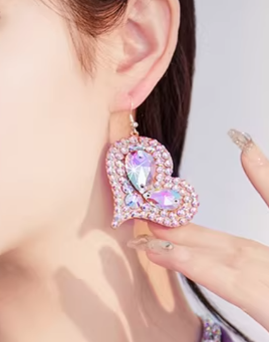 耳元に着用したハート型のベリーダンスアクセサリーのピアスとイヤリング。衣装やレッスン着に合わせた際のサイズ感と輝きが分かるアップ構図。