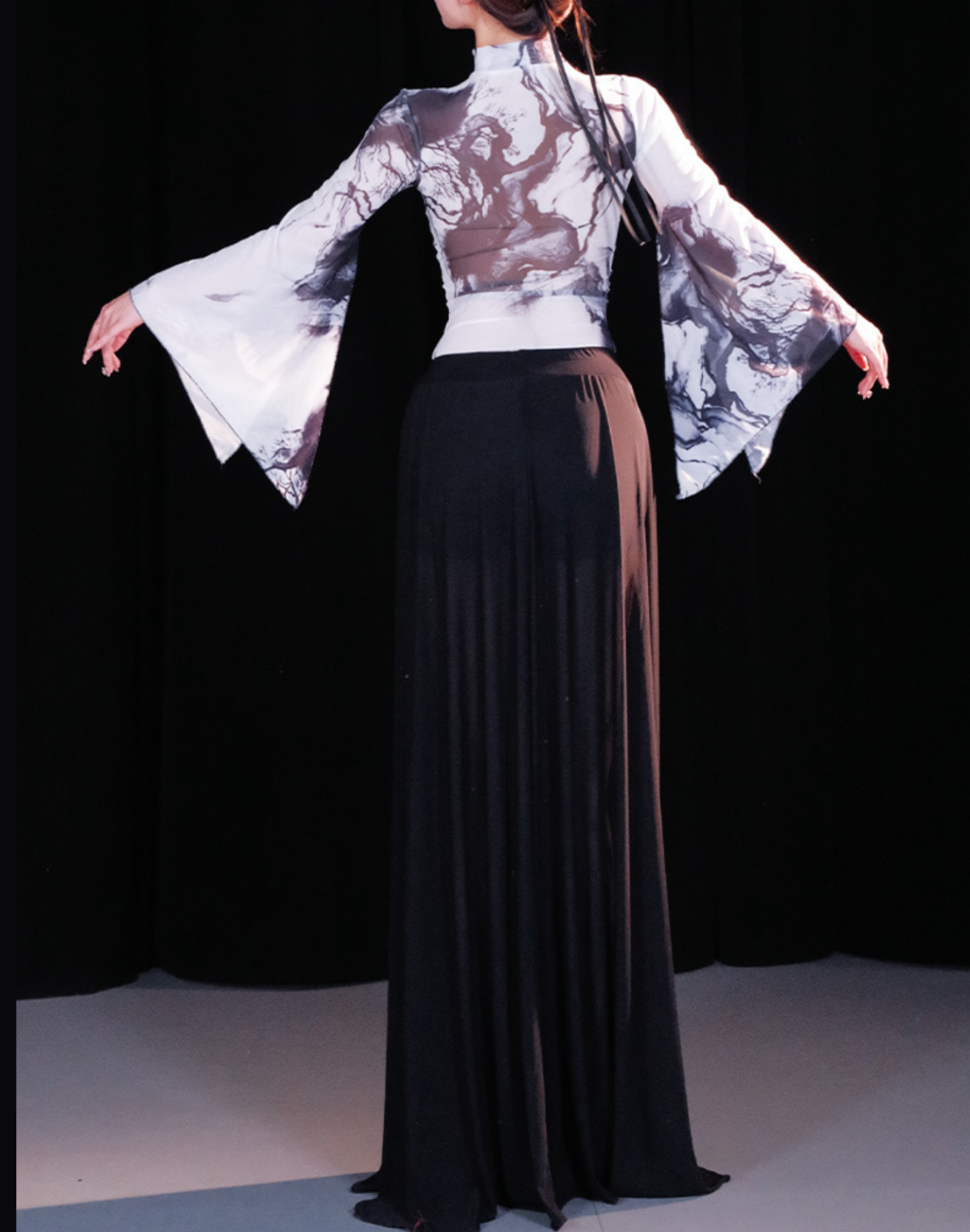 ベリーダンス衣装にも使えるレッスン着セットアップを背面から撮影。腕を広げたポーズで、動きに合わせたシルエットが確認できる画像。