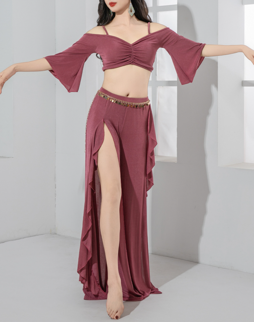 左腕を横に伸ばしたポーズで撮影した、パープルのベリーダンス衣装としても使えるレッスン着で、フリル付きワイドパンツの形が見える。