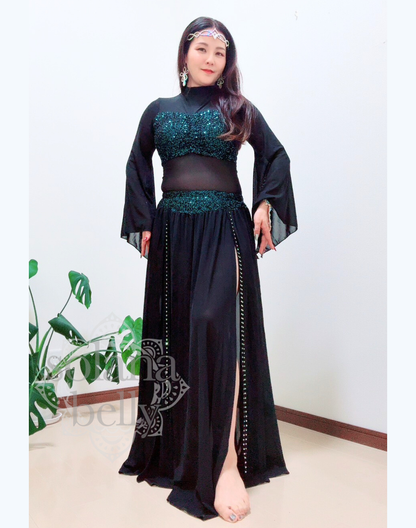 黒のトップスとスカートが一体となったデザインを着用するベリーダンス レッスン着 衣装、袖口が広がりガラベーヤワンピース風に見えるスタイル