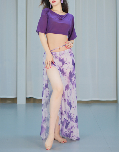 パープルのレッスン着を着た女性が腕を広げて舞う瞬間。袖の揺れが美しく、ベリーダンス衣装としても印象に残るデザイン。