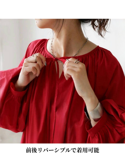 ガラベーヤワンピースのネックラインを調整する紐を結ぶ手元のアップで、ベリーダンス レッスン着の上から着ても動きやすい仕様が分かる写真。