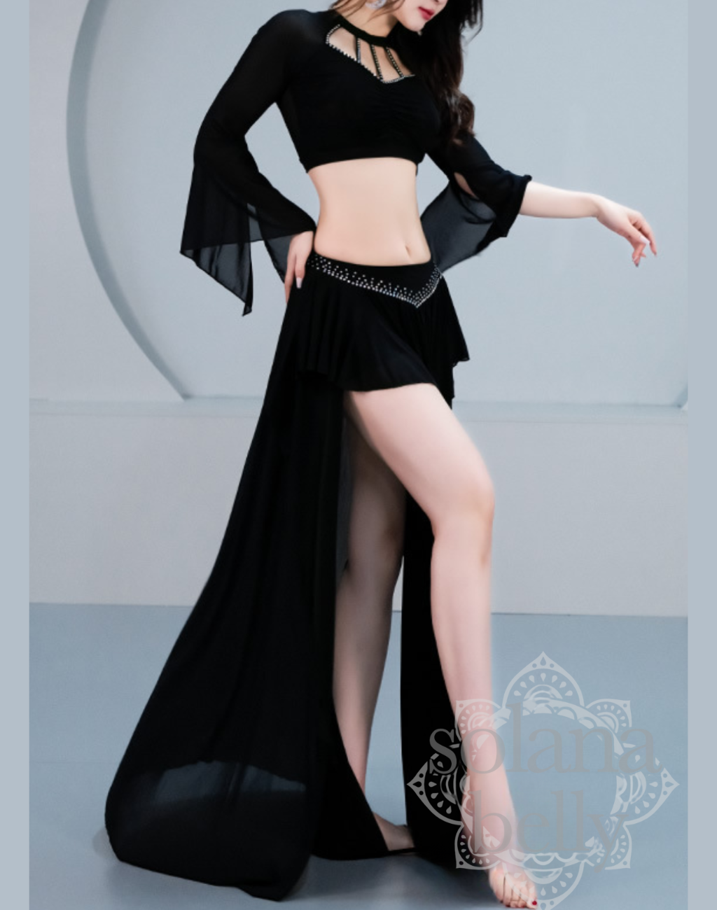 スリットから脚線が見えるブラックのセットアップを着用し、ベリーダンス衣装として踊ったときの動きやすさが分かるレッスン着の着用イメージ