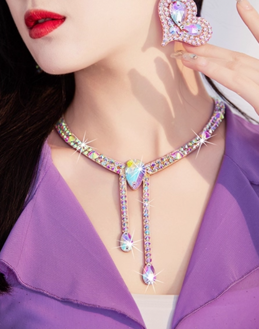 モデルが紫の衣装に合わせてビジュー付きネックレスを着用し、ベリーダンス衣装の胸元を華やかに見せる写真。