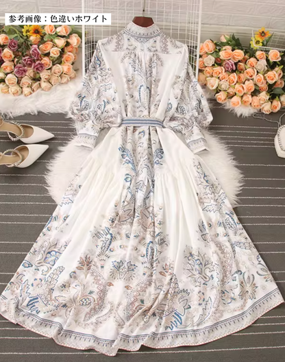 背中まで流れる装飾模様が印象的なホワイトのガラベーヤワンピース。ショーや発表会の移動にも使いやすい。