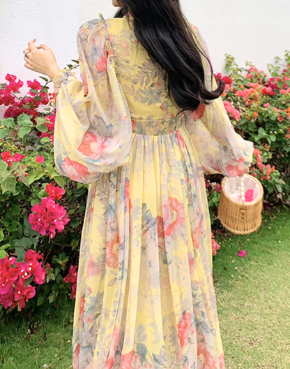 背面から見たイエローのガラベーヤワンピースを、ベリーダンス衣装・レッスン着の上に羽織った状態で、柄の配置と軽やかな素材感が分かる写真。