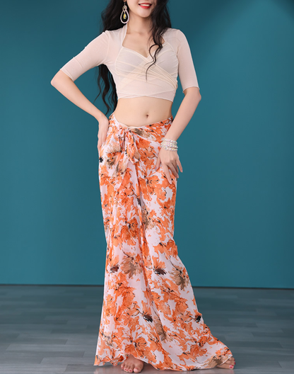 ベージュトップスとオレンジ花柄の巻きスカートを合わせたベリーダンス衣装としても使えるレッスン着で正面に立つ姿