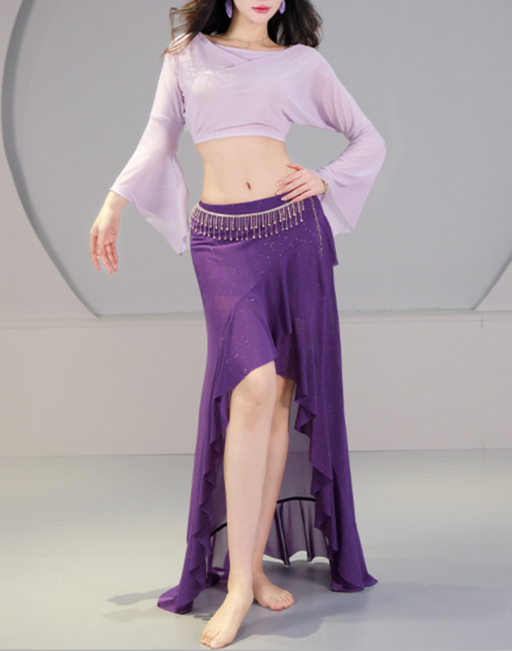 パープルのベリーダンス レッスン着を正面から着用した全身写真。スリット入りスカートと長袖トップスで、初心者にも分かりやすく衣装としても使えるバランスを確認できる。