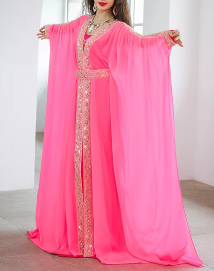 腕を上げた状態で袖から流れる布の落ち感を見せた、ピンクのベリーダンス衣装 ハリージドレス。ステージ上での動きを想定しやすい構図。