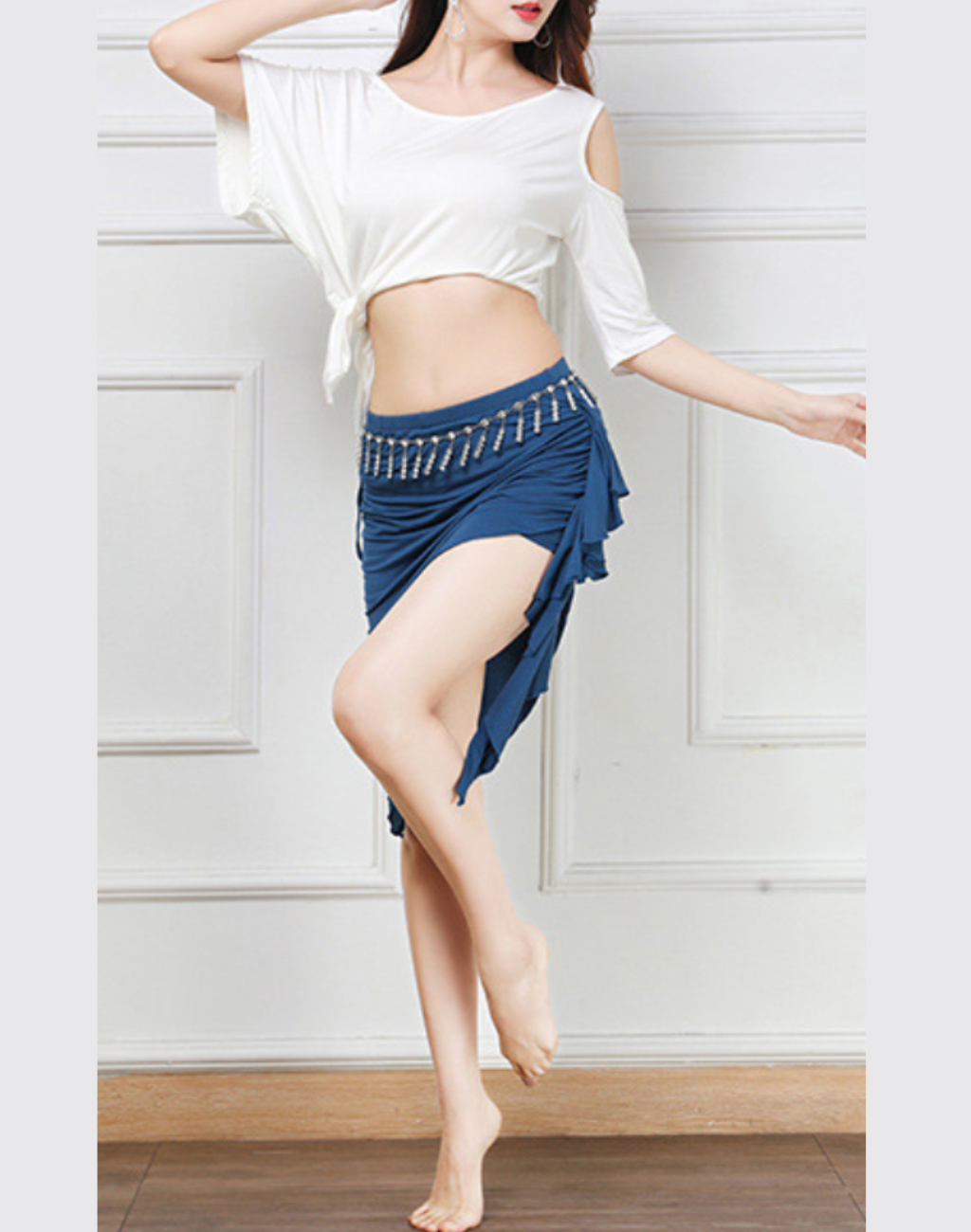 動きのあるポーズで着用したホワイト／ブルー配色のベリーダンス レッスン着。足の動きが見えやすく、練習中の動作確認に使いやすい一着。