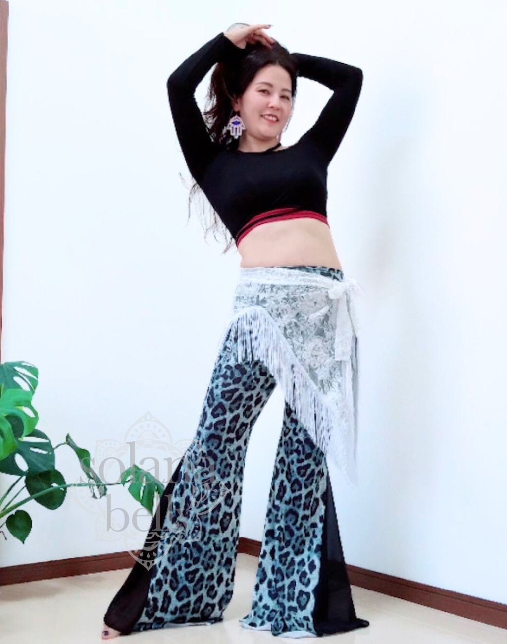 ベリーダンス衣装としても使えるレッスン着を着用し、腕を大きく上げたポーズで踊る様子が分かる写真。動きに合わせたシルエットが伝わるベリーダンス向けの着用イメージ。