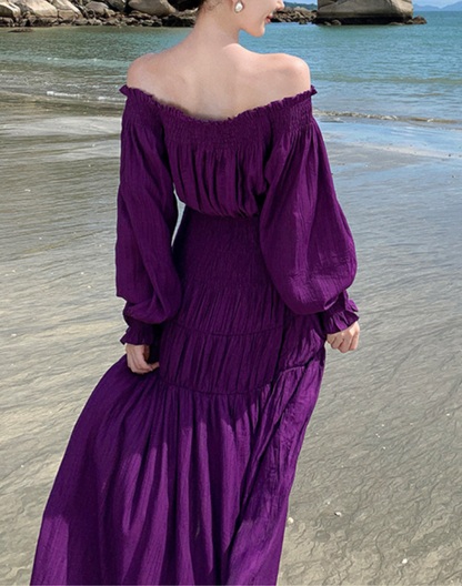 海辺でワンピースの裾が大きく風に揺れる後ろ姿の写真。軽く柔らかな素材がベリーダンスのレッスン着や衣装にも重ねやすく、動きのあるシルエットが分かるショット。