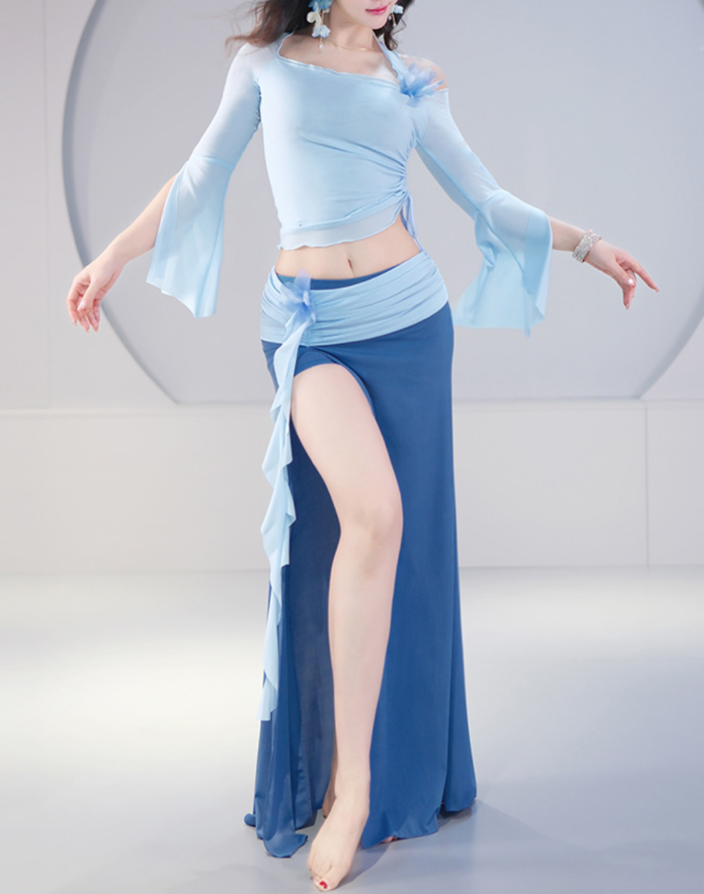 ライトブルーのトップスと深いブルーのスカートを合わせたベリーダンスのレッスン着。衣装としても使えるデザインで、上品な配色と軽やかな動きが印象的。