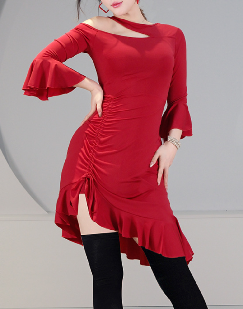 アシンメトリーなデコルテが印象的なレッドのワンピースを着用し、ベリーダンスの動きで身体のラインがわかる初心者にも使いやすい衣装兼レッスン着の着用イメージ。