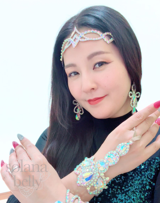 モデルがベリーダンス衣装と合わせて着用したクラウン風ビジューヘッドアクセサリー。額のラインを引き立てる大粒ビジューが特徴。