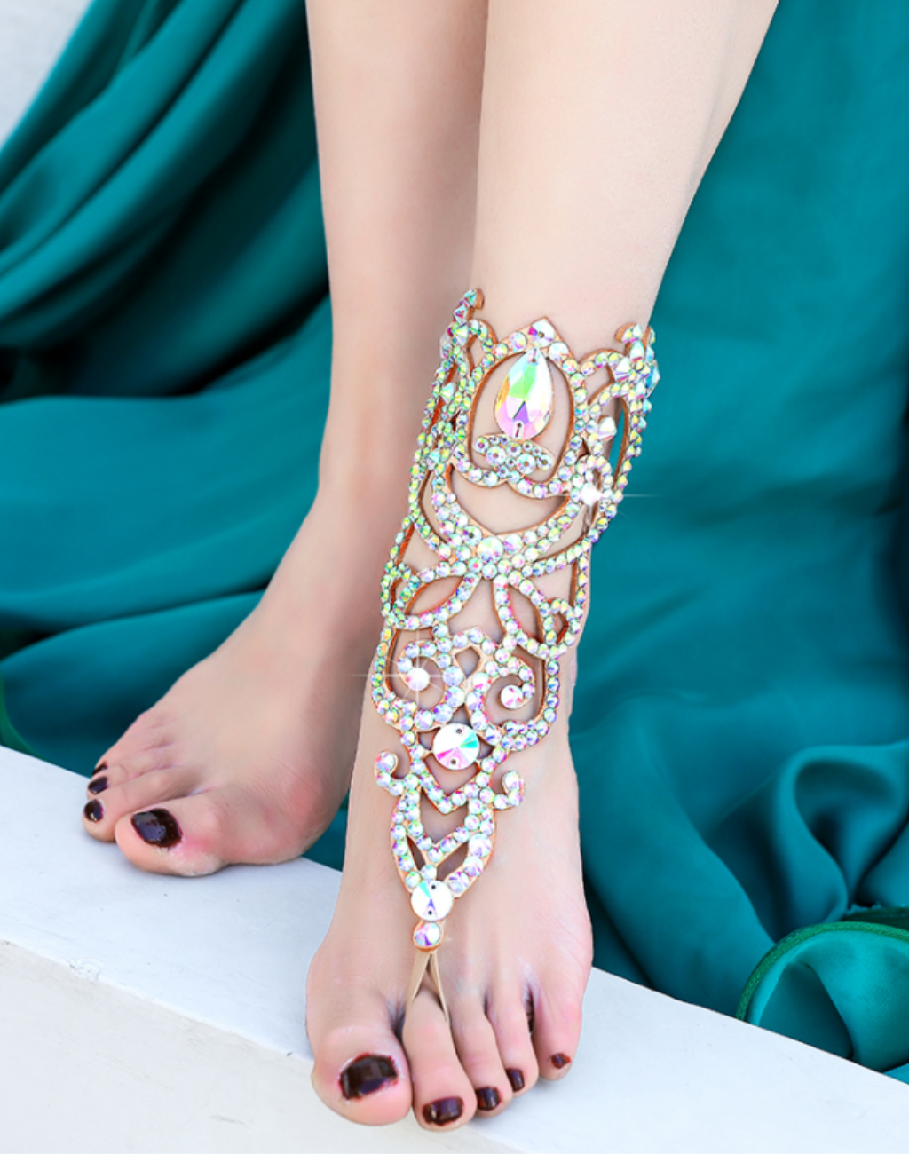 足首から甲までビジューが連なるベリーダンス用フットアクセサリーを着用した足元のアップ。衣装にもレッスン着にも合わせやすいデザインで、光を受けて細かなストーンが輝く様子がわかる構図。